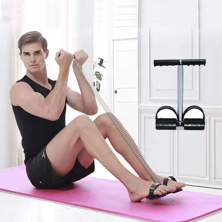 Man using an exercise device on a pink mat with a white wall background
